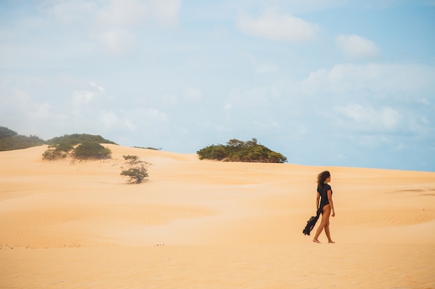 Bella giovane donna in posa nella sabbia del deserto