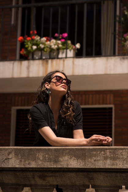 Bella giovane donna in posa su un balcone