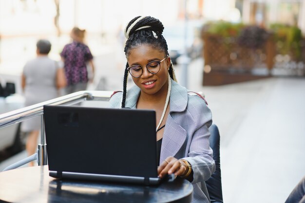 Bella giovane donna in un caffè utilizzando un computer portatile