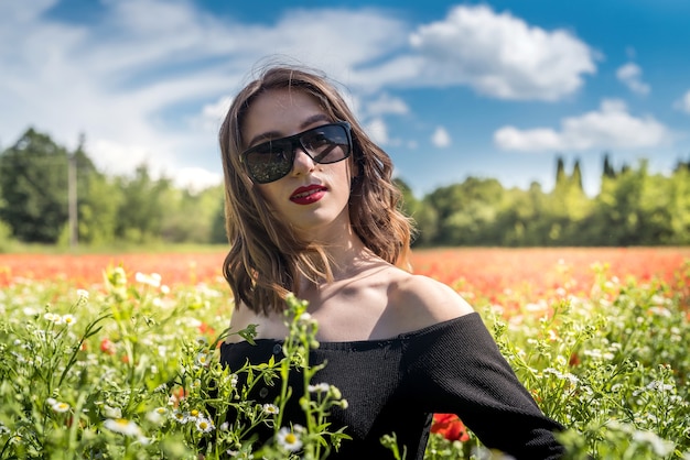 Bella giovane donna in un campo di fiori margherite, godersi la natura