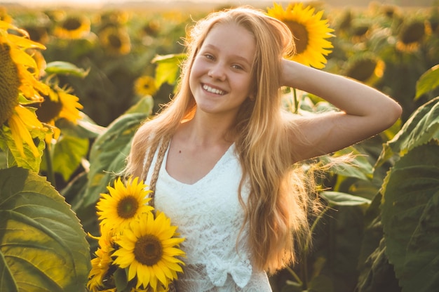 Bella giovane donna in un campo di girasoli. Ritratto di una giovane donna al sole. Concetto di allergie ai pollini