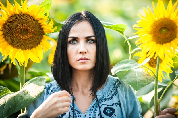 Bella giovane donna in un campo di girasoli