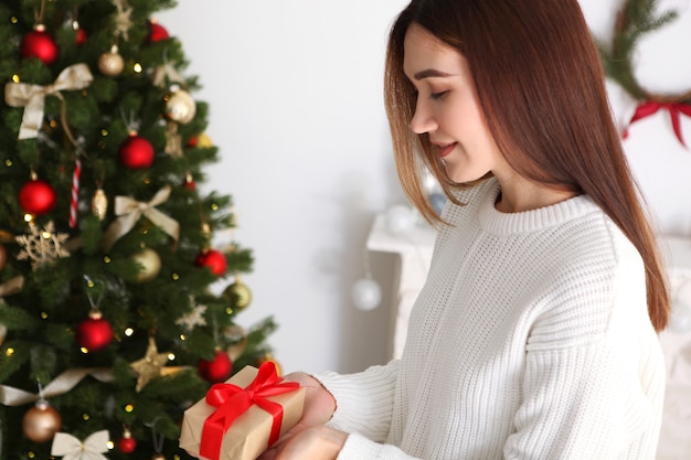 Bella giovane donna in un interno di natale con regali per il testo