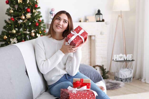 Bella giovane donna in un interno di natale con regali per il testo