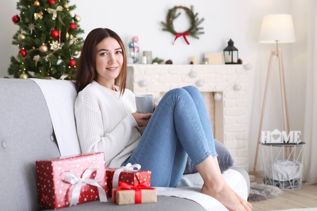 Bella giovane donna in un interno di natale con regali per il testo