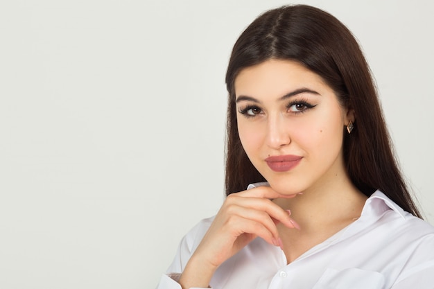 Bella giovane donna in una camicia bianca