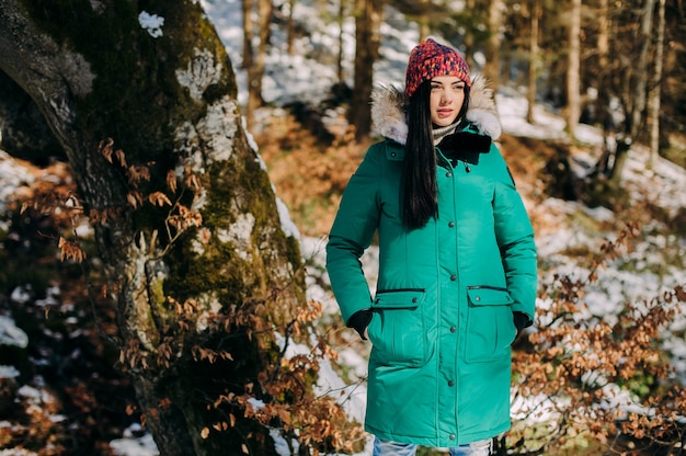 Bella giovane donna in una escursione in una foresta invernale