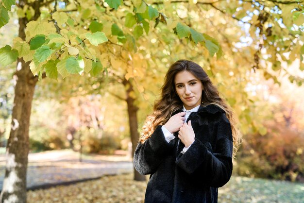 Bella giovane donna in una pelliccia nella magica foresta autunnale.