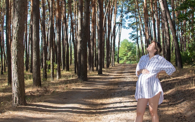 Bella giovane donna incinta respirando profondamente all'aperto nel parco