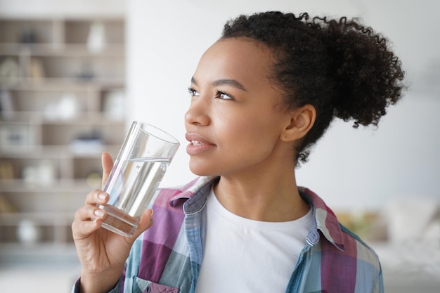 Bella giovane donna ispanica che gode dell'acqua minerale Stile di vita sano fitness e benessere