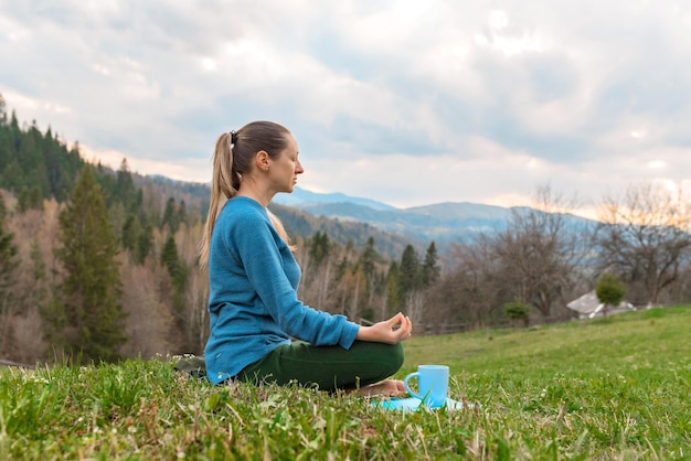 Bella giovane donna meditazione yoga Assana rilassante nella natura in montagna