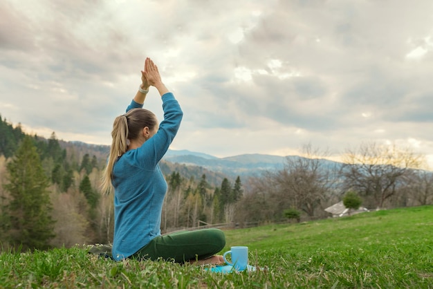 Bella giovane donna meditazione yoga Assana rilassante nella natura in montagna