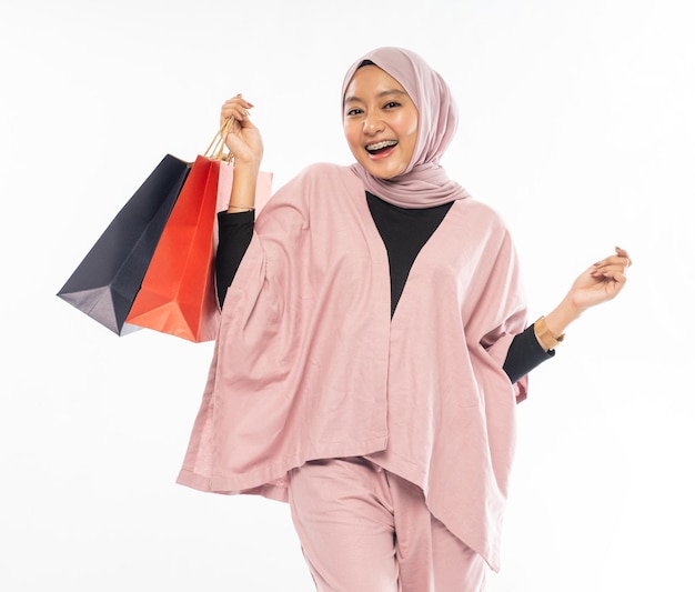 Bella giovane donna musulmana felice in possesso di un sacchetto della spesa