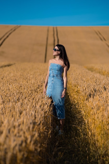 bella giovane donna nel campo di grano dorato