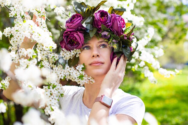 Bella giovane donna nel giardino dei fiori di ciliegio