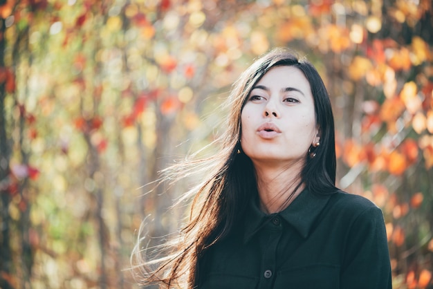 Bella giovane donna nel parco di autunno