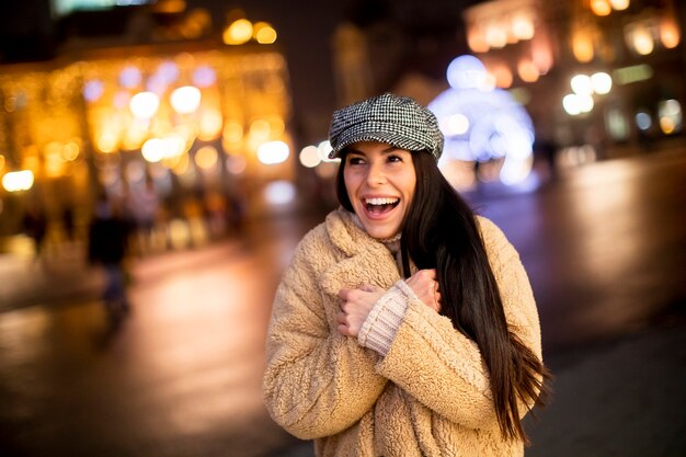 Bella giovane donna per strada nella fredda notte di Natale