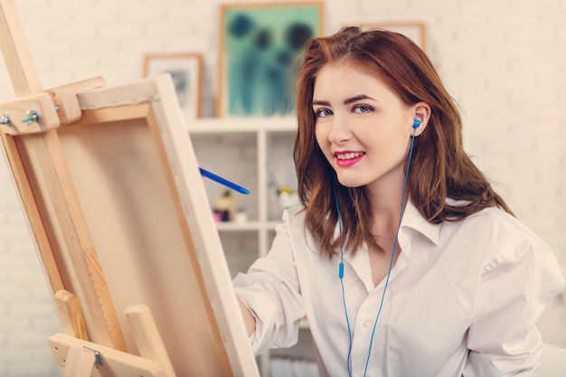 Bella giovane donna pittore al lavoro