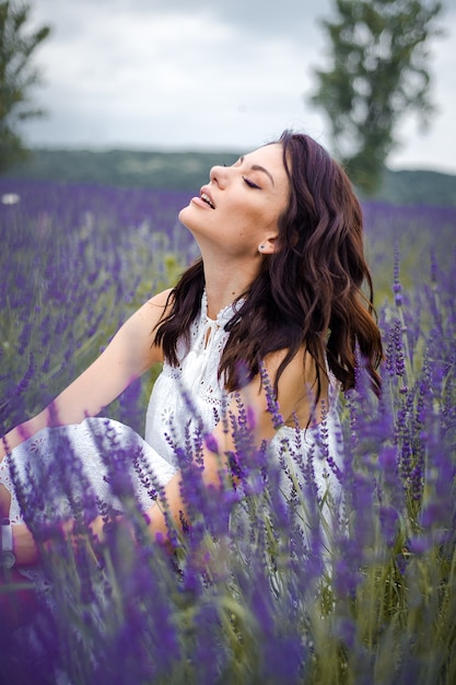 Bella giovane donna sensuale sul campo di lavanda