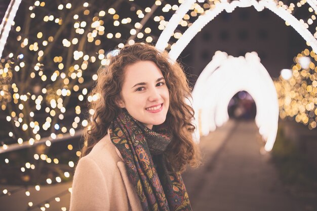 Bella giovane donna sorridente all'aperto con le luci