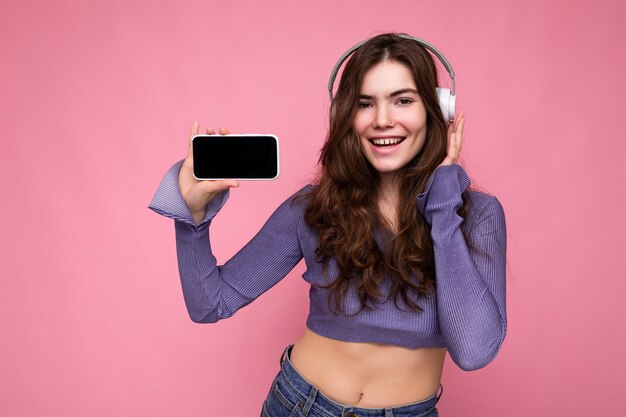 Bella giovane donna sorridente felice che porta vestito casuale alla moda isolato sulla parete del fondo