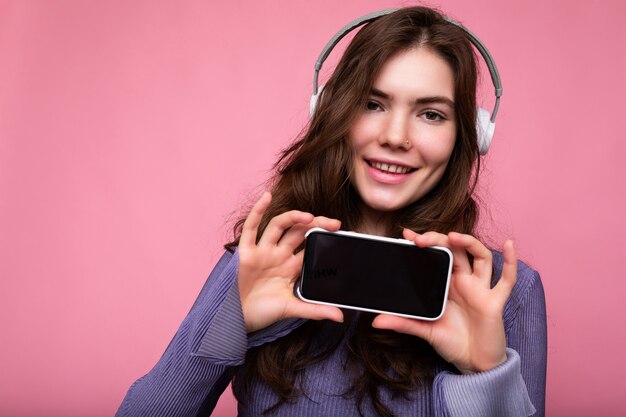 Bella giovane donna sorridente felice che porta vestito casuale alla moda isolato sulla parete del fondo