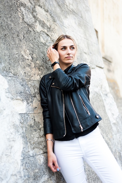 Bella giovane donna sorridente in città di sera