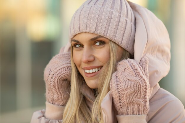 Bella giovane donna sorridente nell'orario invernale all'aperto. Concetto di inverno.