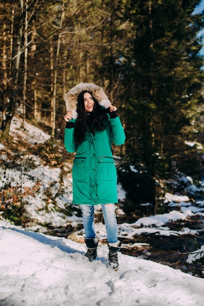 Bella giovane donna su un&#39;escursione in una foresta di inverno