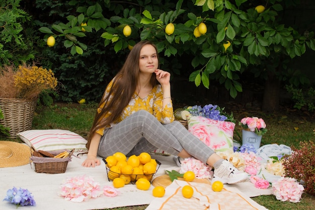 Bella giovane donna su un picnic in giardino