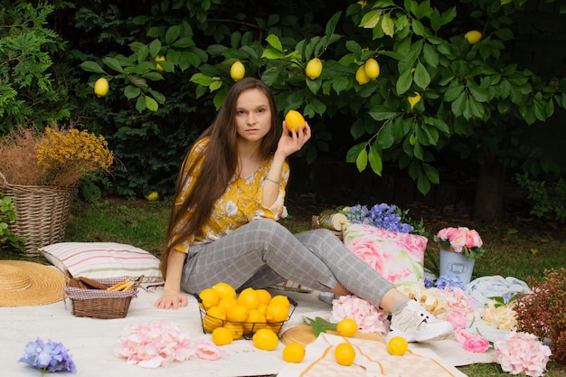 Bella giovane donna su un picnic in giardino