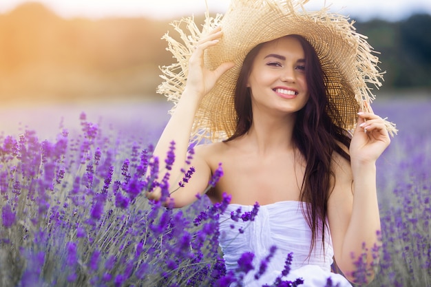 Bella giovane donna sul campo di lavanda. Concetto di aroma. Attraente giovane femmina all'aperto.