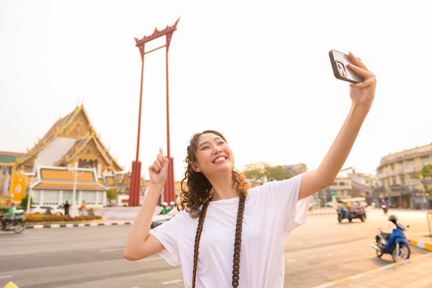 Bella giovane donna turistica asiatica in vacanza visitando ed esplorando la città di Bangkok