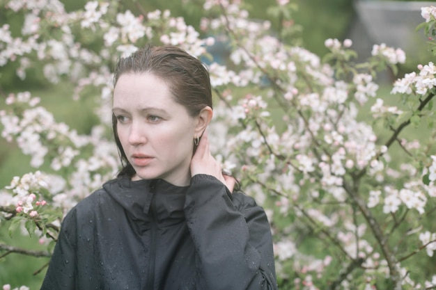 Bella giovane donna vicino all'albero primaverile in fiore La gioventù ama il concetto romantico e di stile di vita della moda