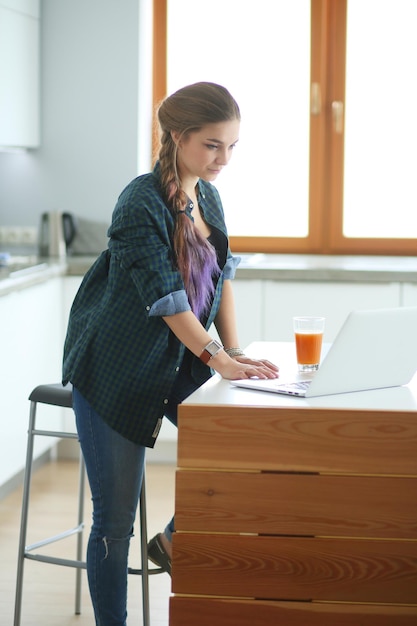 Bella giovane dottoressa sorridente che si siede allo scrittorio e che scrive