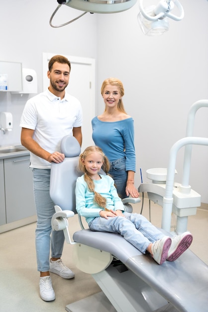 bella giovane famiglia che guarda l'obbiettivo presso l'ufficio del dentista