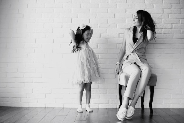 Bella giovane famiglia con figlie durante un servizio fotografico in uno studio bianco