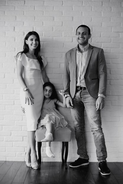 Bella giovane famiglia con figlie durante un servizio fotografico in uno studio bianco