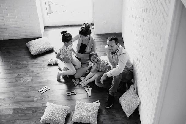 Bella giovane famiglia con figlie durante un servizio fotografico in uno studio bianco