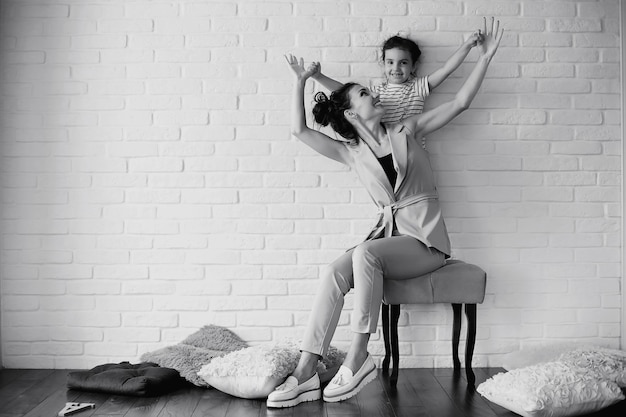 Bella giovane famiglia con figlie durante un servizio fotografico in uno studio bianco