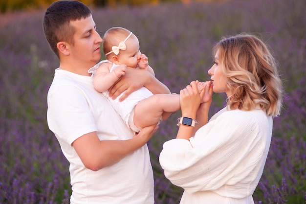 Bella giovane famiglia sul campo di lavanda fiore viola. Vacanze di famiglia