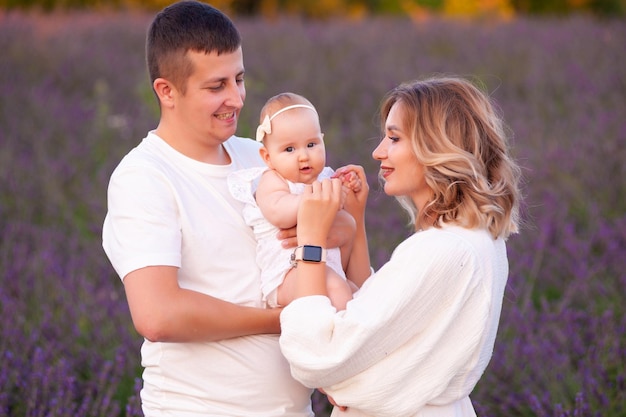 Bella giovane famiglia sul campo di lavanda fiore viola. Vacanze di famiglia