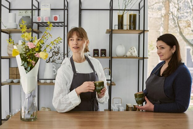 Bella giovane fiorista che beve caffè con sua madre