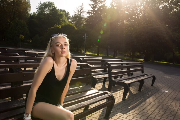 Bella giovane modella in abiti alla moda e scarpe da ginnastica bianche con gli occhiali