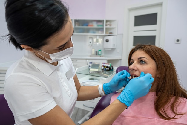 Bella giovane paziente è venuta da un dentista femminile per il trattamento della carie dei denti malati