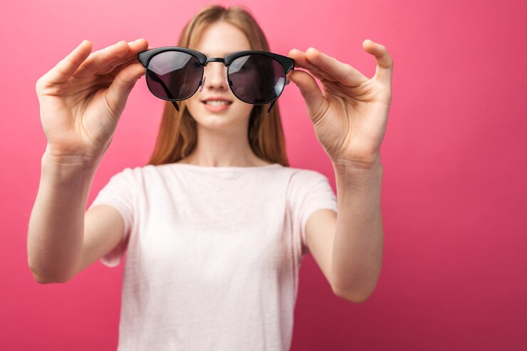 Bella giovane ragazza bionda in vetri che stanno sui jeans da portare della parete dentellare