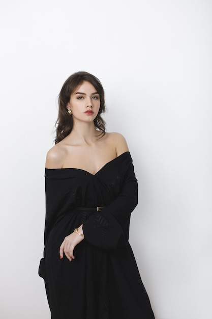 Bella giovane ragazza castana in vestito nero