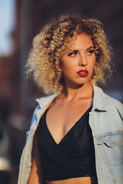 Bella giovane ragazza caucasica con capelli ricci all'aperto