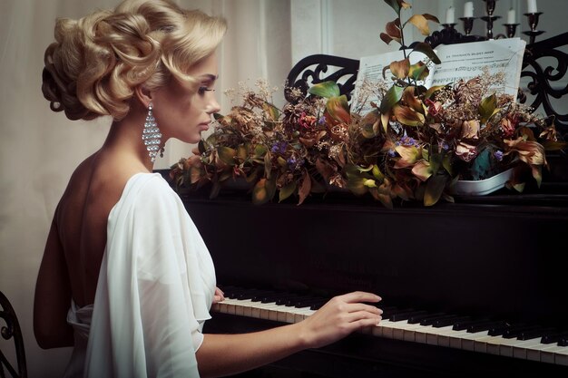 Bella giovane sposa che suona il pianoforte