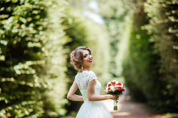 Bella giovane sposa con bouquet da sposa